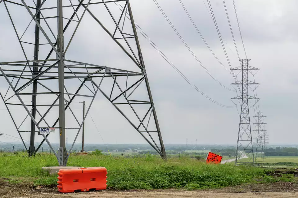 Base of a transmission tower, with more towers in the distance