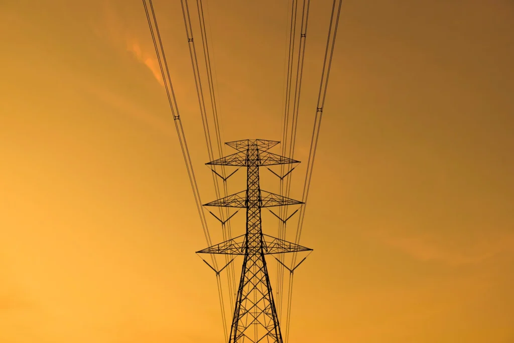 Transmission tower against an orange sky