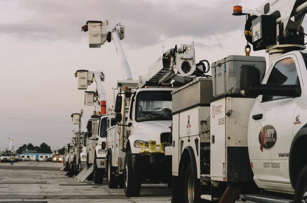 Utility bucket trucks lined up in a staging lot